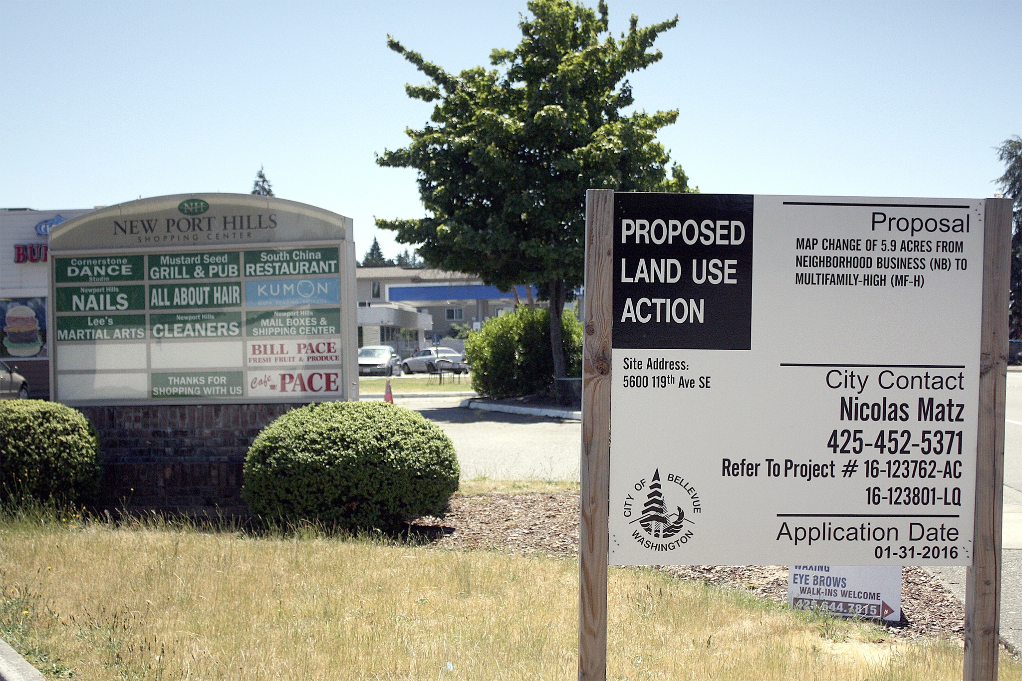 A proposed land use action sign sits in front of the tenant sign at the Newport Hills Shopping Center on 119th Avenue Southeast. Bill Pace produce on the sign closed its doors last year