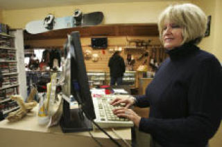 Cash Company pawn shop owner Nancy Robinson works behind the counter on Monday