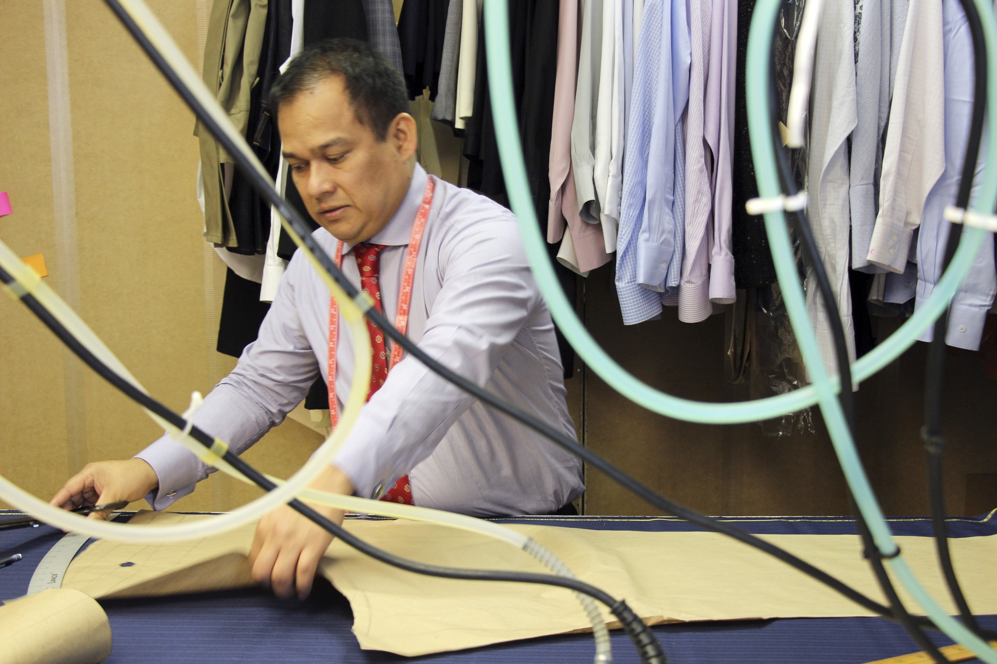 Gabriel Lopez traces a customer’s measurements onto suiting wool at his shop