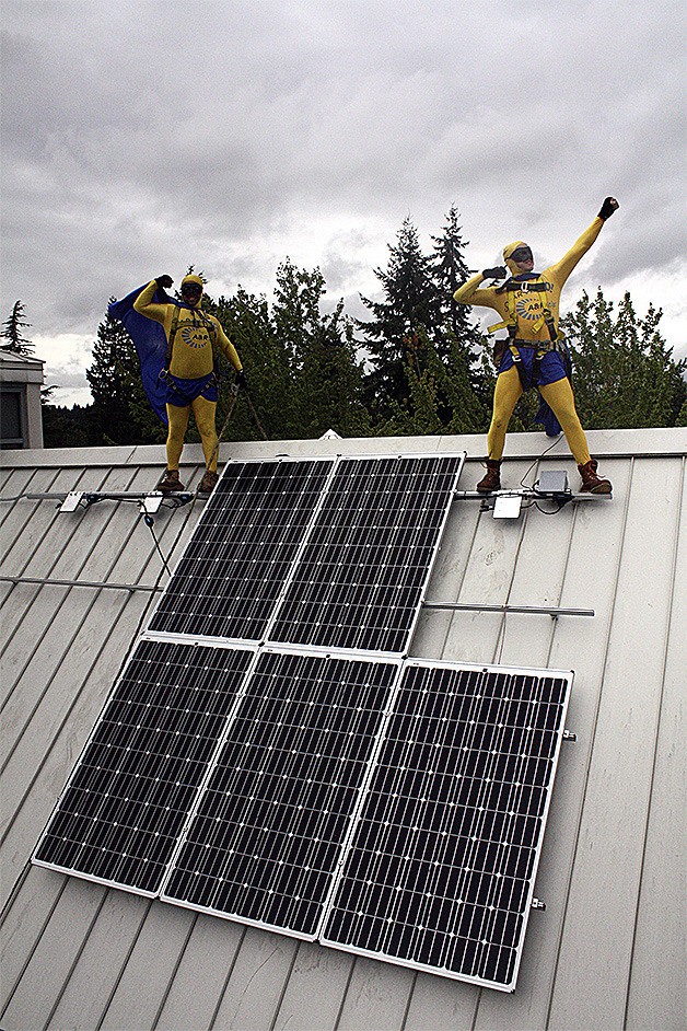 Two ‘superheroes’ from A&R Solar install pose after installing solar panels on the roof of the new KidsQuest Museum.