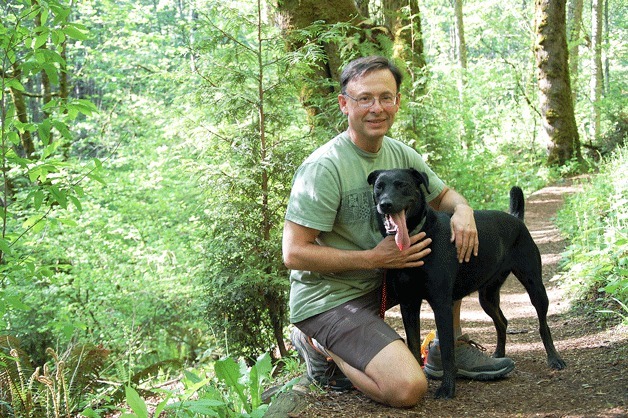 Stephen Cobert and his dog Maddy pause on one of the trails near his home in Bellevue’s Forest Glen East neighborhood.