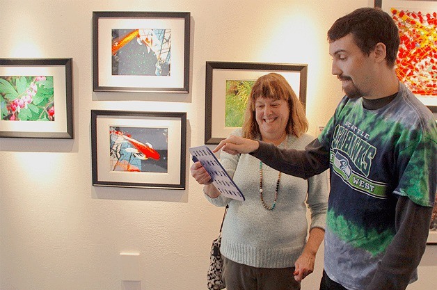 Photographer Forrest Sargent explains the joy he gets from taking photographs in front of his art on exhibit in Bellevue.