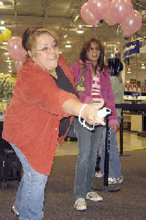 Silvia Otero tries her hand at Wii bowling at the Bellevue Best Buy store as Michelle McConnell looks on.