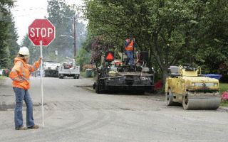 Construction workers repair and overlay a street in the Overlake area Thursday