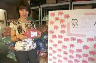 World Impact Network’s Executive Director Gabriella Van Breda poses with the piggy banks that are used to collect money to raise $50
