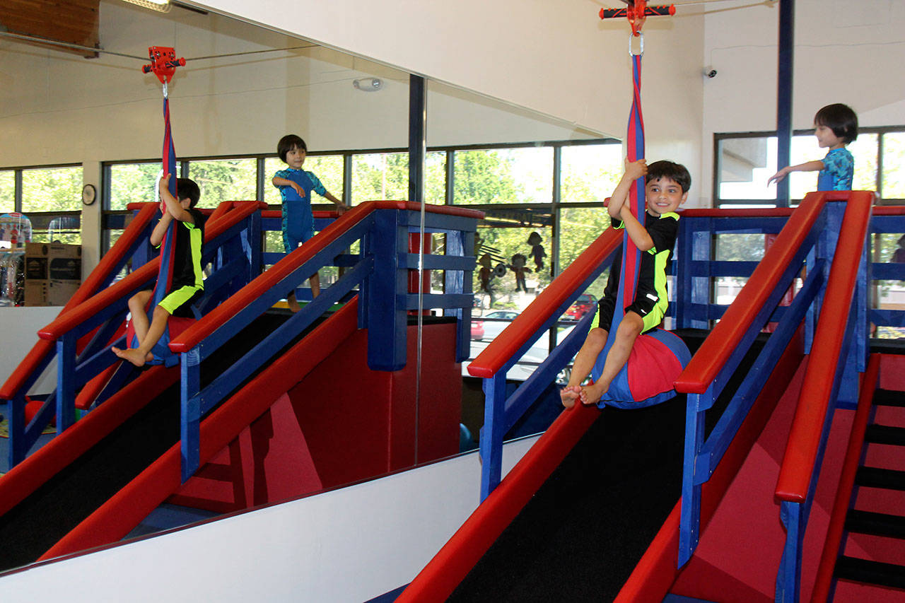 Nicholas launches from the gym’s slide to jet across the room on a zip line. Raechel Dawson/staff photo