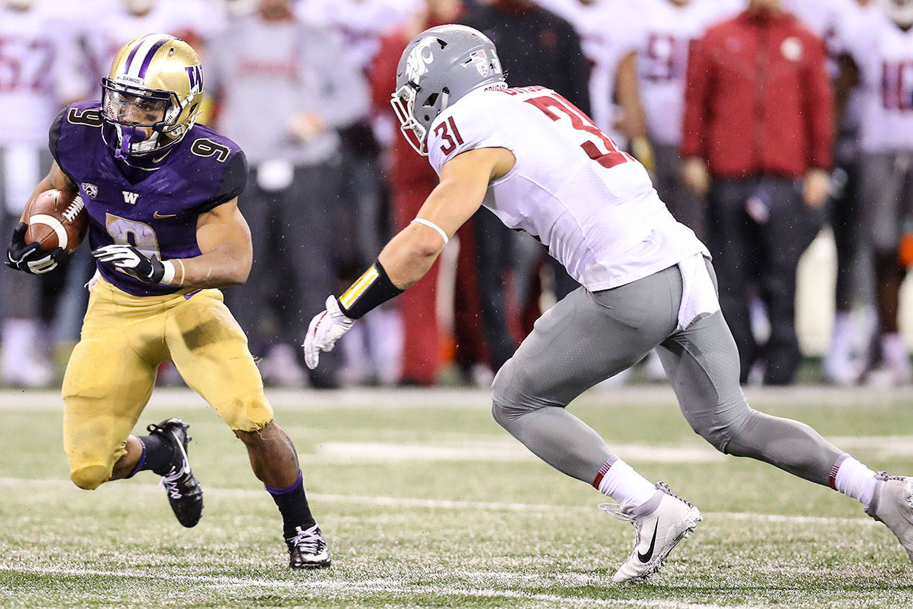 Photo courtesy of Rick Edelman/Rick Edelman Photography                                Newport Knights 2013 graduate Isaac Dotson had seven tackles (three solo tackles) for the Washington State Cougars football team against the University of Washington Huskies in the Apple Cup on Nov. 26. The Huskies defeated the Cougars 41-14. Dotson (right), chased Huskies running back Myles Gaskin, left, in the above picture.