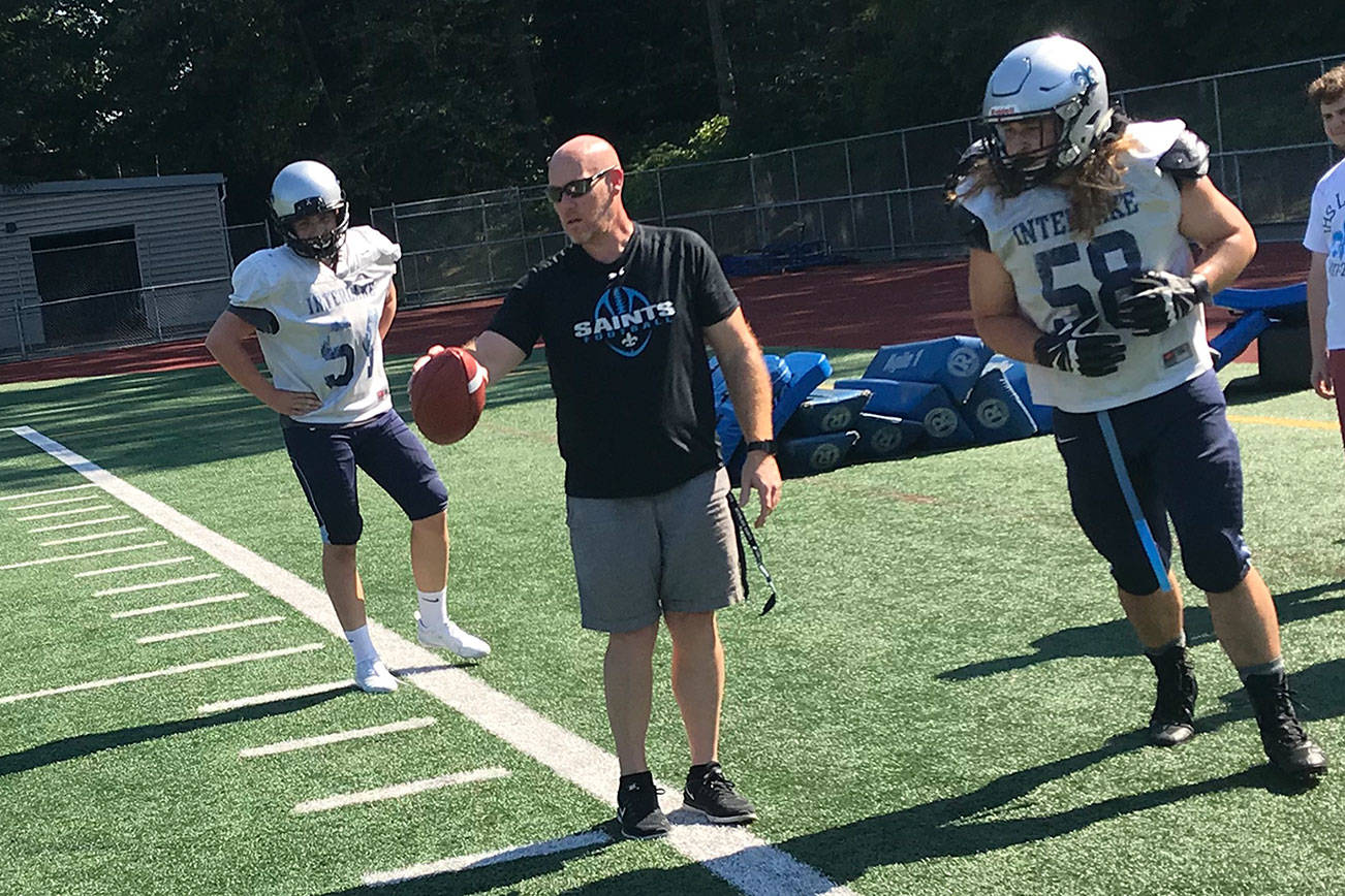 Interlake Saints head football coach Shawn Hartline, center, makes a point to one of his players during a spring practice session on June 19 at Interlake High School in Bellevue. Hartline, who will be in his first season as head coach of the Saints this fall, was an assistant on the Saints staff during the 2016 and 2017 seasons. Shaun Scott, staff photo