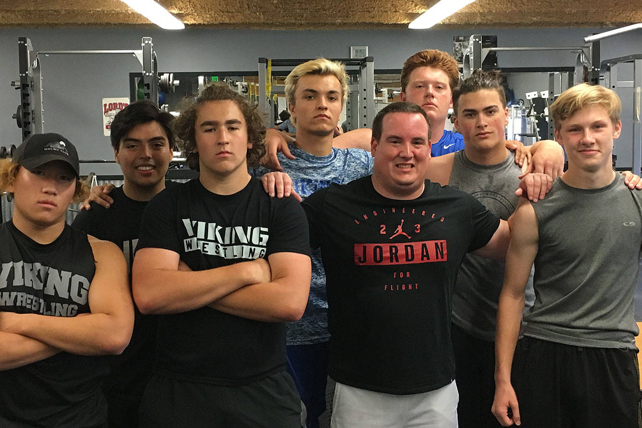 Sound Publishing sportswriter Shaun Scott poses for a quick picture with members of the Bellevue Christian Vikings football team following a weight training session on July 19 at Bellevue Christian School in Bellevue.                                Photo courtesy of Todd Green