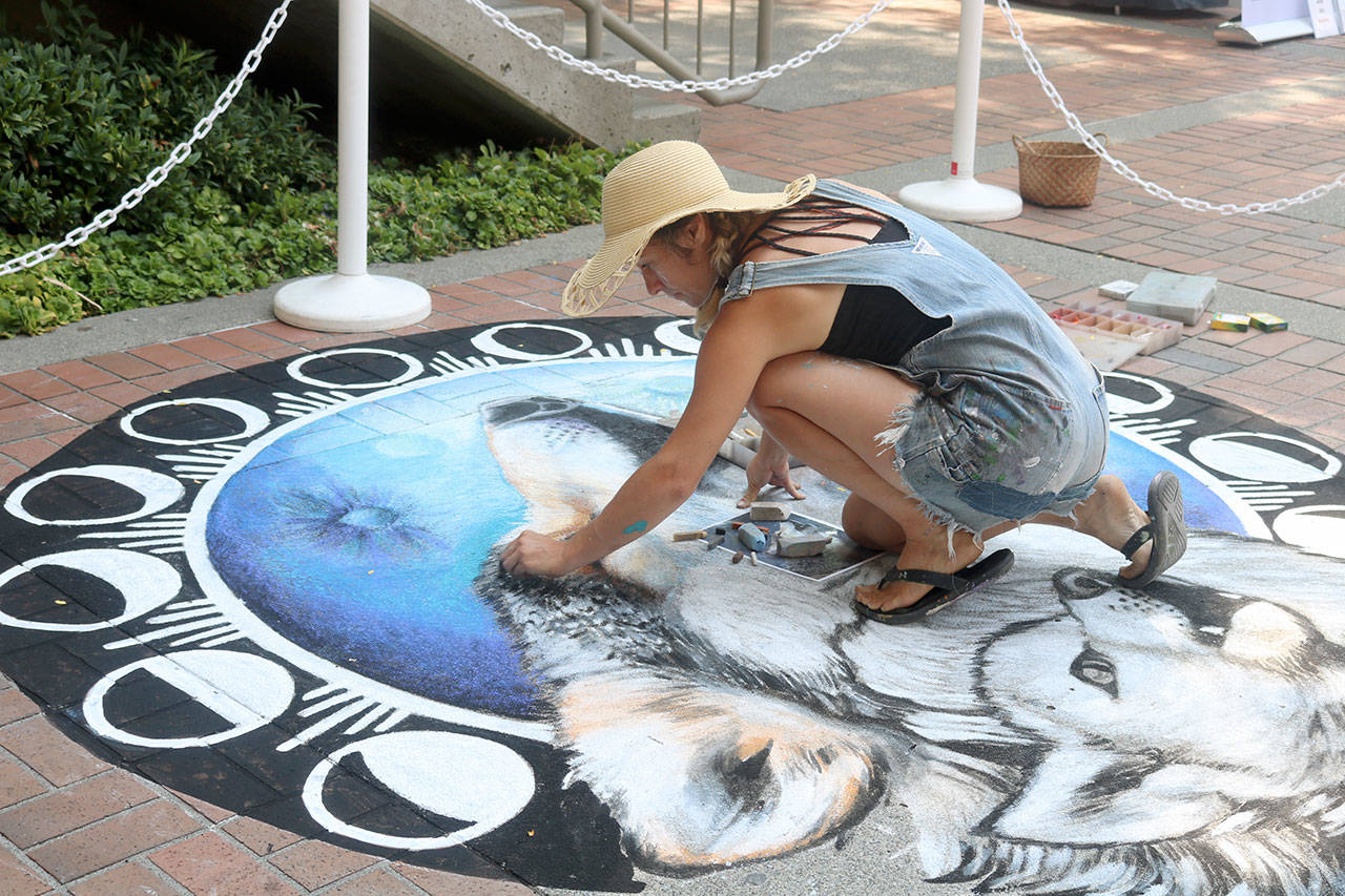 Gabrielle Abbott, an award-winning chalk artist, muralist, and fine artist from Seattle, does live art on the brick flooring near the door to the mall. Evan Pappas/staff photo