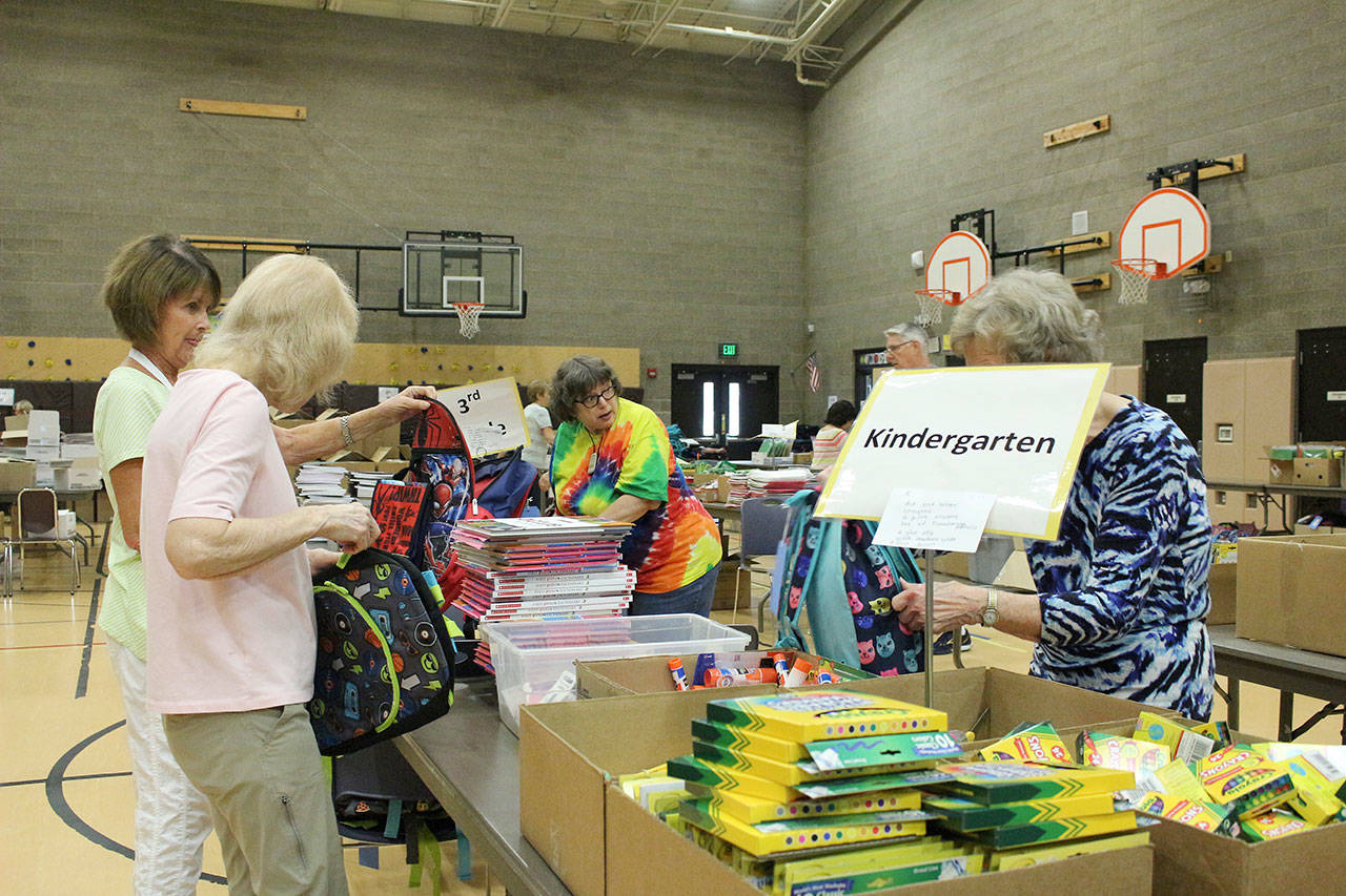 Volunteers pack backpacks according to the students’ needs. Madison Miller/staff photo.