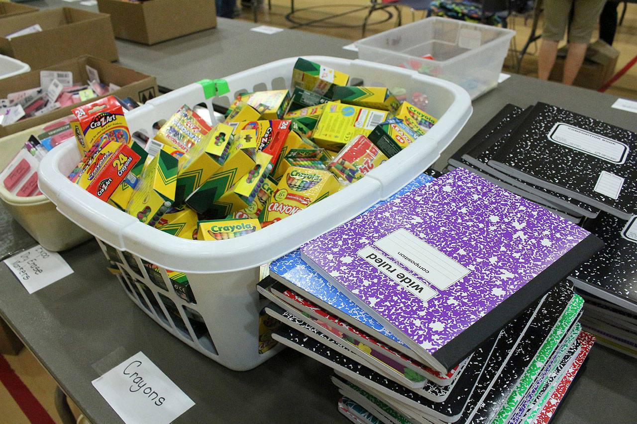 Table of school supplies waiting to be organized and sorted into backpacks. Madison Miller/staff photo.