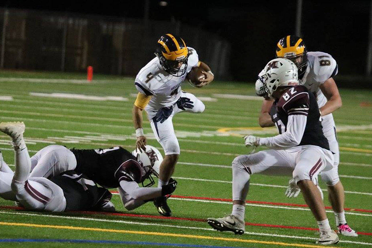 Wolverines quarterback Joey Echigoshima rumbles for yardage against the Mercer Island Islanders in October of 2017. Echigoshima will be in his second season as the starting quarterback this fall. Photo courtesy of Don Borin/Stop Action Photography