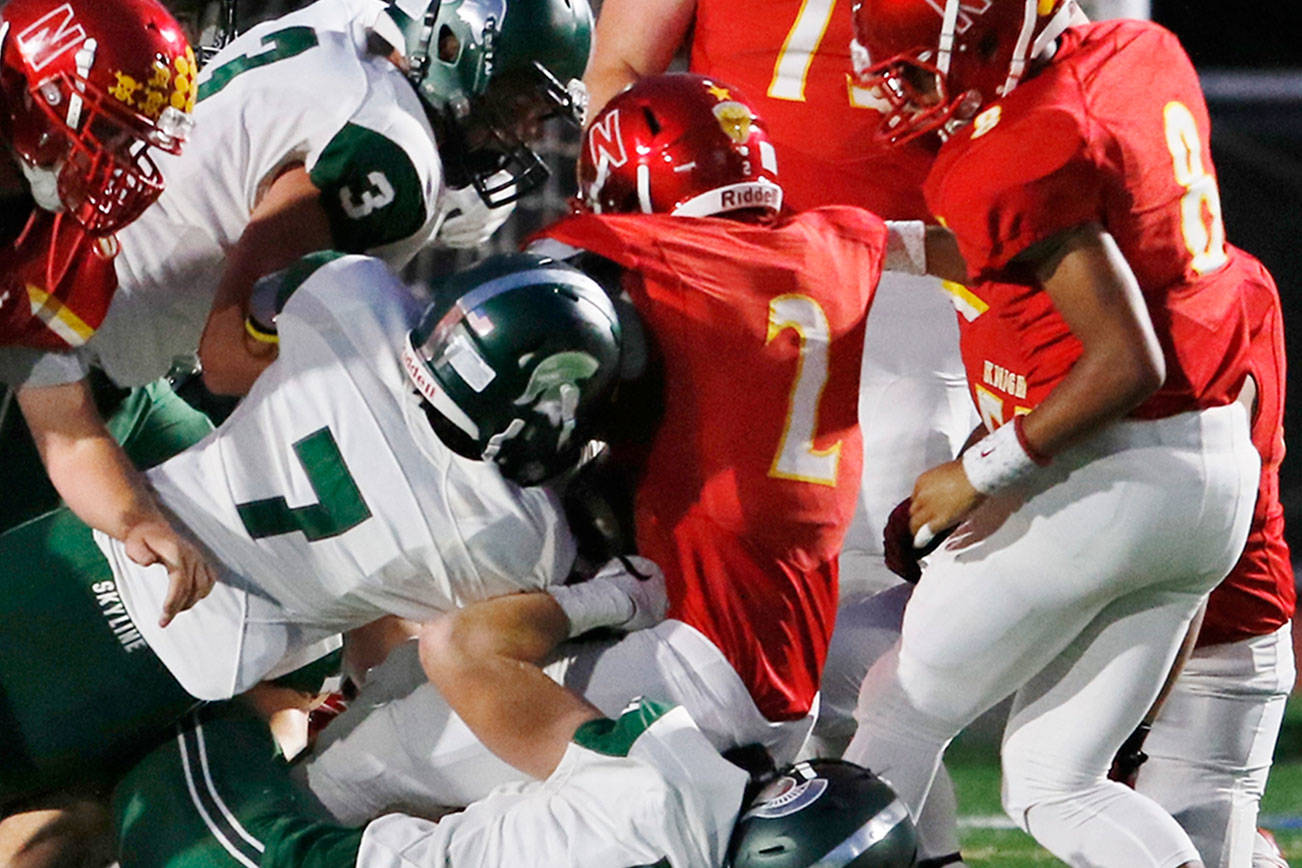 Newport Knights running back Trey Wikstrom battles for extra yardage against the Skyline Spartans defense. Skyline defeated Newport 50-21 on Sept. 21 at Newport High School in Factoria. Photo courtesy of Jim Nicholson