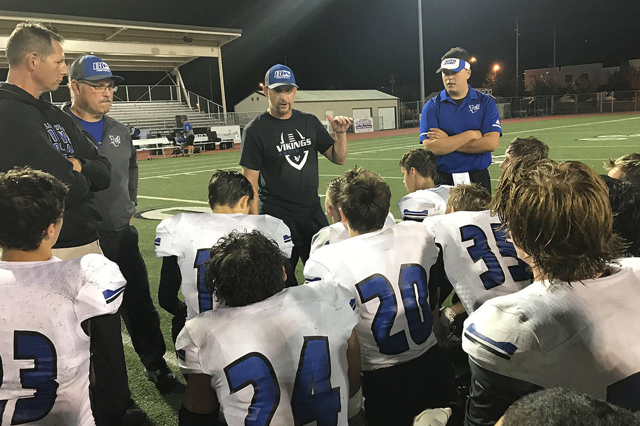 Bellevue Christian Vikings head coach Todd Green, center, addresses his team on the field at Sunset Chev Stadium in Sumner following their 45-7 loss to the Cascade Christian Cougars on Sept. 29. Shaun Scott/staff photo