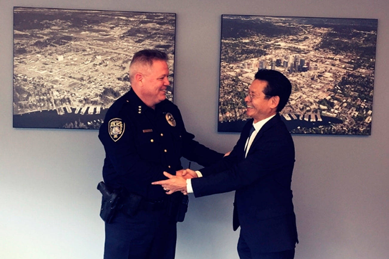 Bellevue city manager Brad Miyake welcomes Steve Mylett back to his position as police chief following his exoneration. Photo courtesy of the city of Bellevue