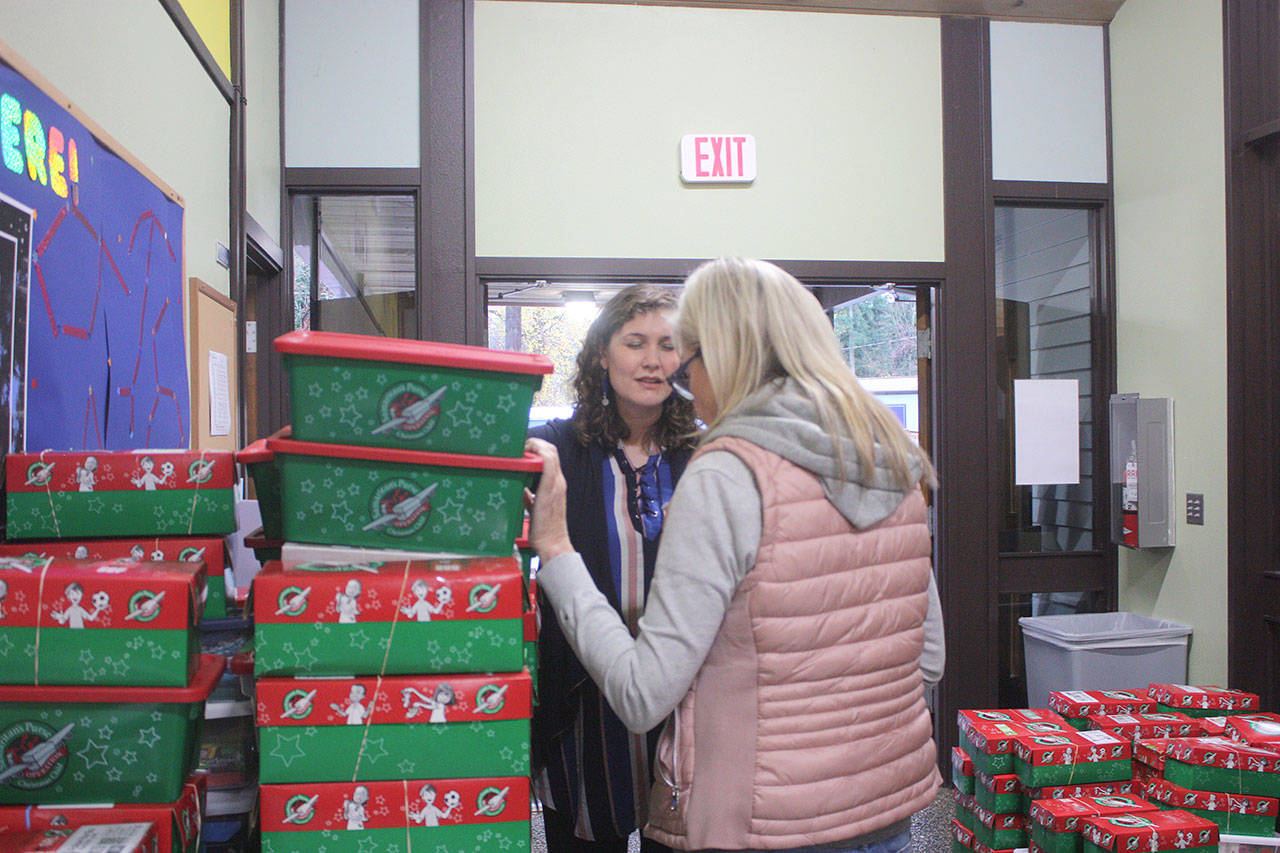 Operation drop-off center leader at ECS, Paige Benton, prays over boxes with family who brought in seven shoeboxes on Nov. 15. Stephanie Quiroz/staff photo.