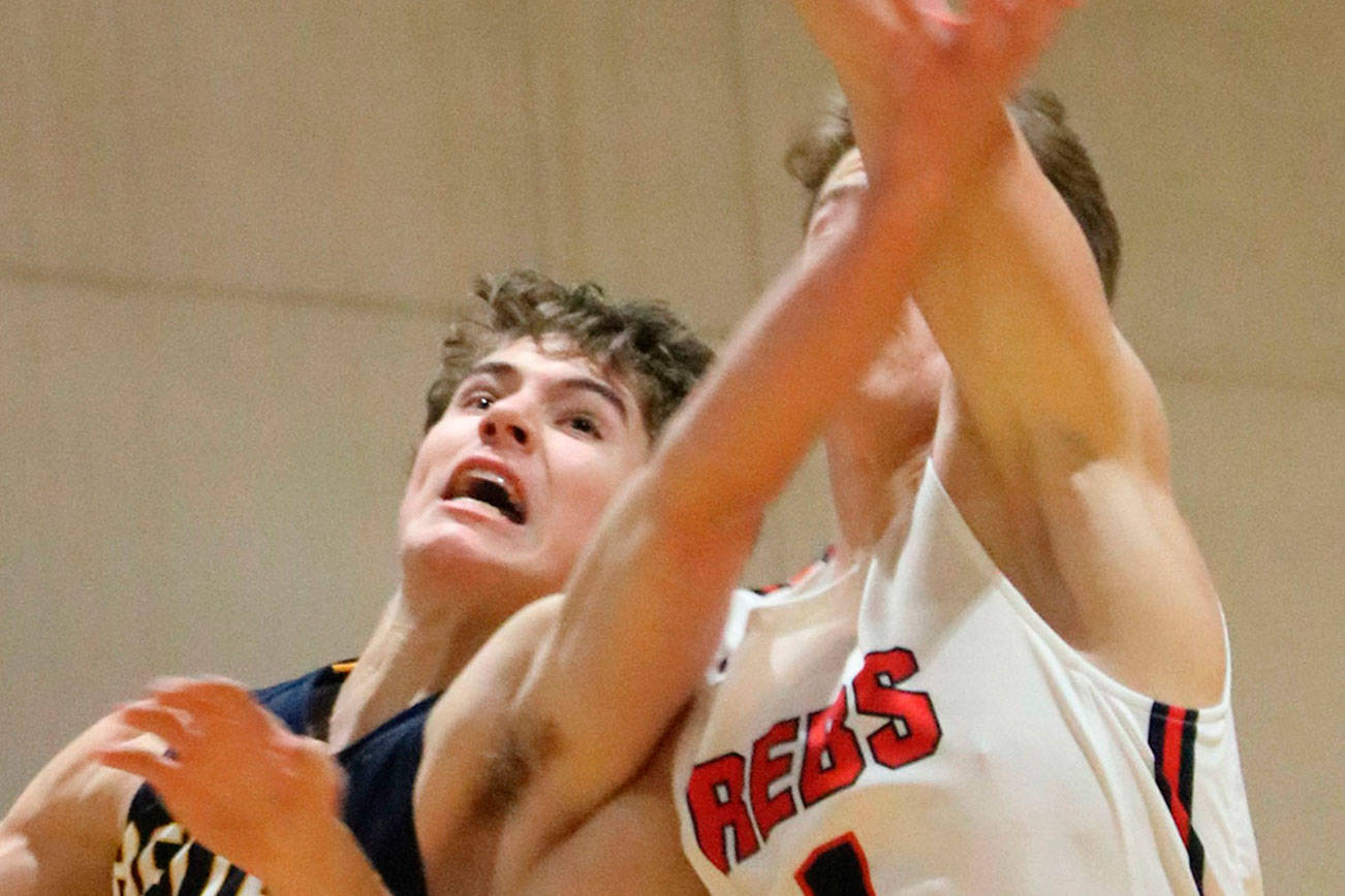 Bellevue player McCallum Mead, left battles Juanita’s Nathan Robertson in the paint during a 3A KingCo contest on Dec. 4 at Juanita High School in Kirkland. The Wolverines defeated the Rebels 61-48 to improve their overall record to 1-1. Andy Nystrom, staff photo