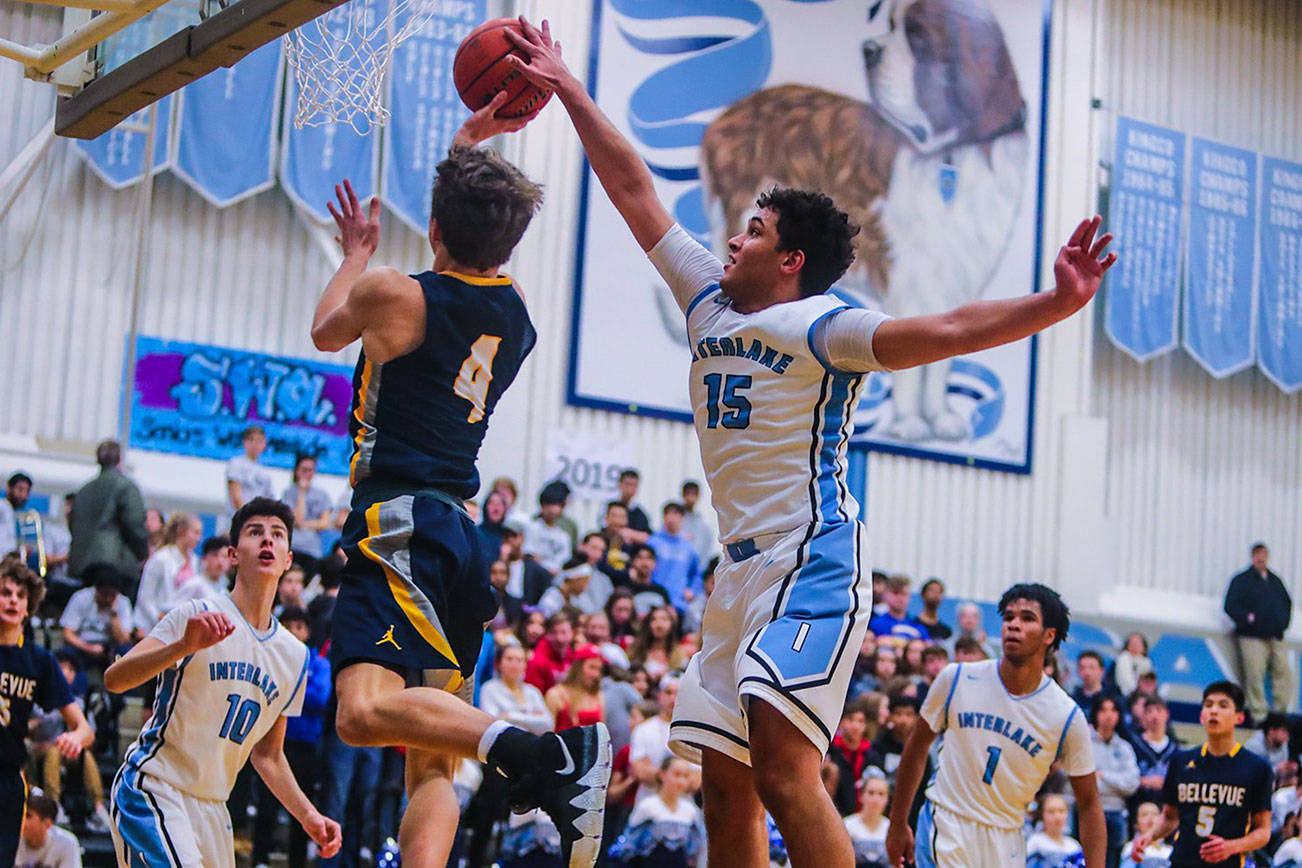 The Bellevue Wolverines earned a 44-37 victory against the Interlake Saints in a 3A KingCo basketball matchup on Dec. 7 at Interlake High School in Bellevue. Bellevue improved its overall record to 2-1 with the win while Interlake dropped to 1-2 with the loss. Interlake forward Myles Chandler, right, blocks Bellevue player McCallum Mead’s shot during the matchup between rival schools. Photo courtesy of Don Borin/Stop Action Photography