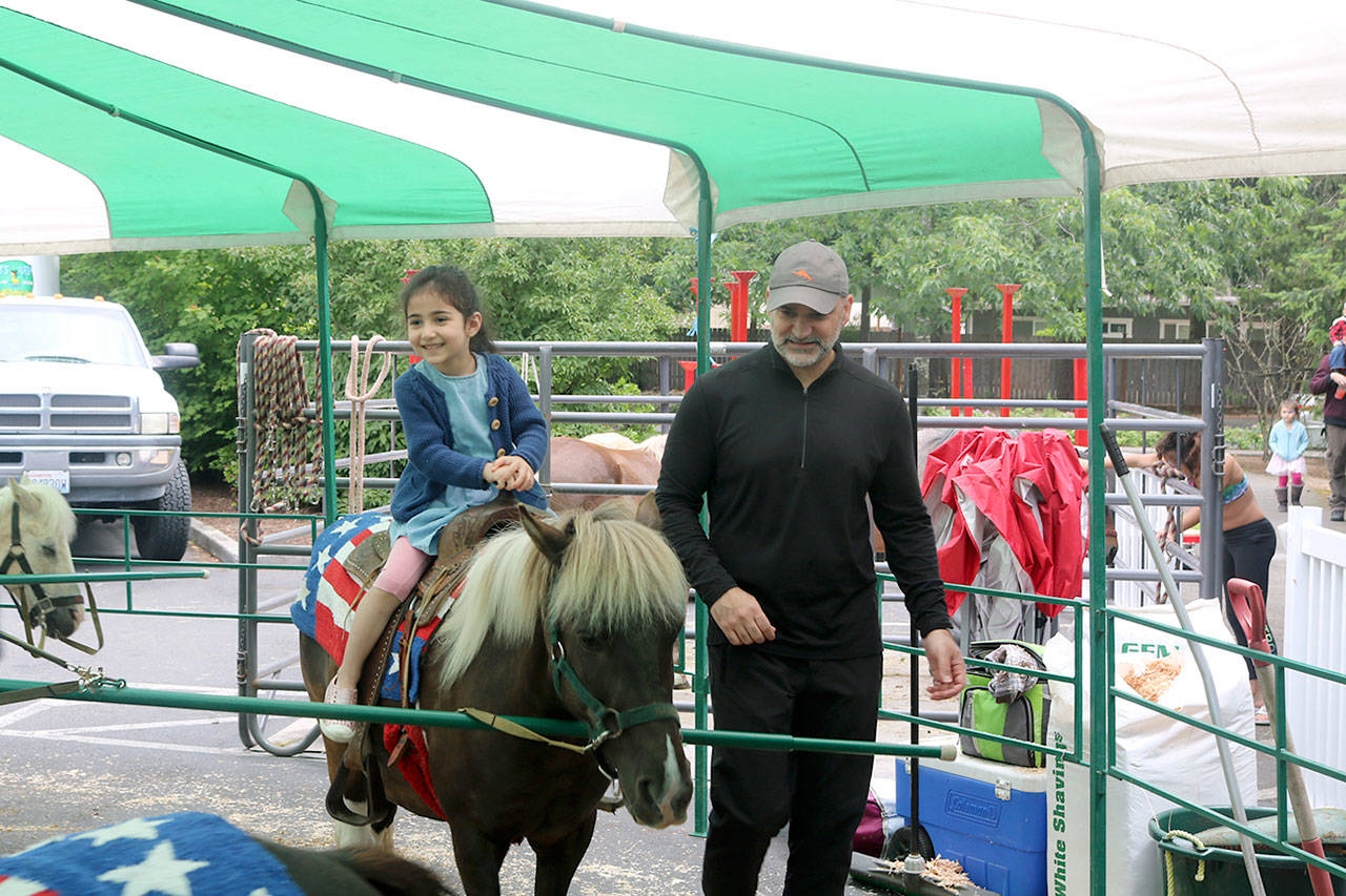 The Ghanaati family takes their daughter for a pony ride at the festival. Evan Pappas/Staff Photo