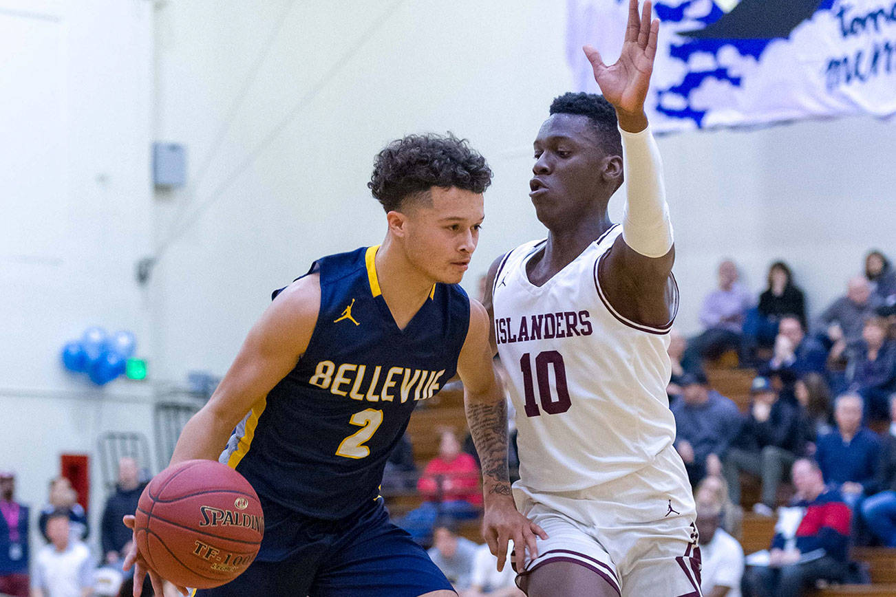 Bellevue Wolverines senior Jalen Love, left, dribbles down the court while being covered by Mercer Island guard Nigel Seda, right, during the 3A KingCo tournament championship game on Feb. 6. Love scored 12 of his 14 points in the second half of play. Mercer Island defeated Bellevue 44-41. Photo courtesy of Patrick Krohn/Patrick Krohn Photography