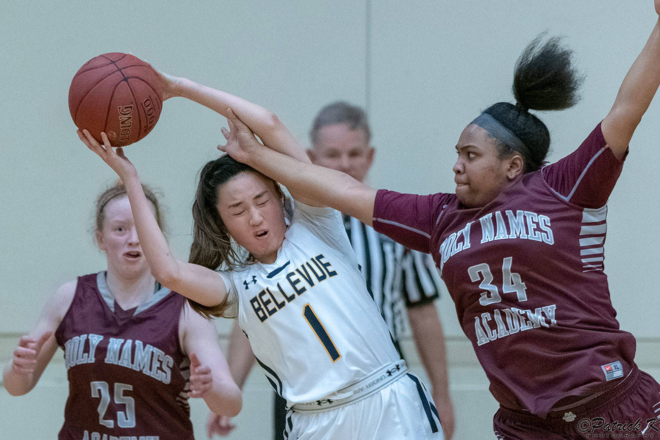 Bellevue Wolverines junior Kara Choi, center, controls the ball while being defended by Holy Names Academy Cougars players Bria Stokes, right, and Stefanie Hale, left. Holy Names earned a 49-48 victory against Bellevue in a loser-out game on Feb. 14 at Bellevue High School. Photo courtesy of Patrick Krohn/Patrick Krohn Photography