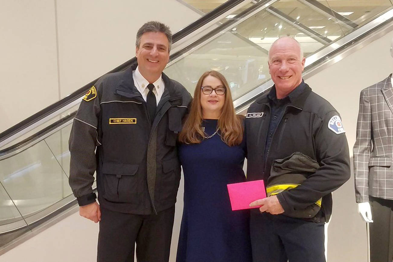 Chief Hagen and Firefighter Williams accept nearly $2,000 in donations made at the till. $6,000 was raised in total at Nordstrom. Photo courtesy of Bellevue Fire Department.
