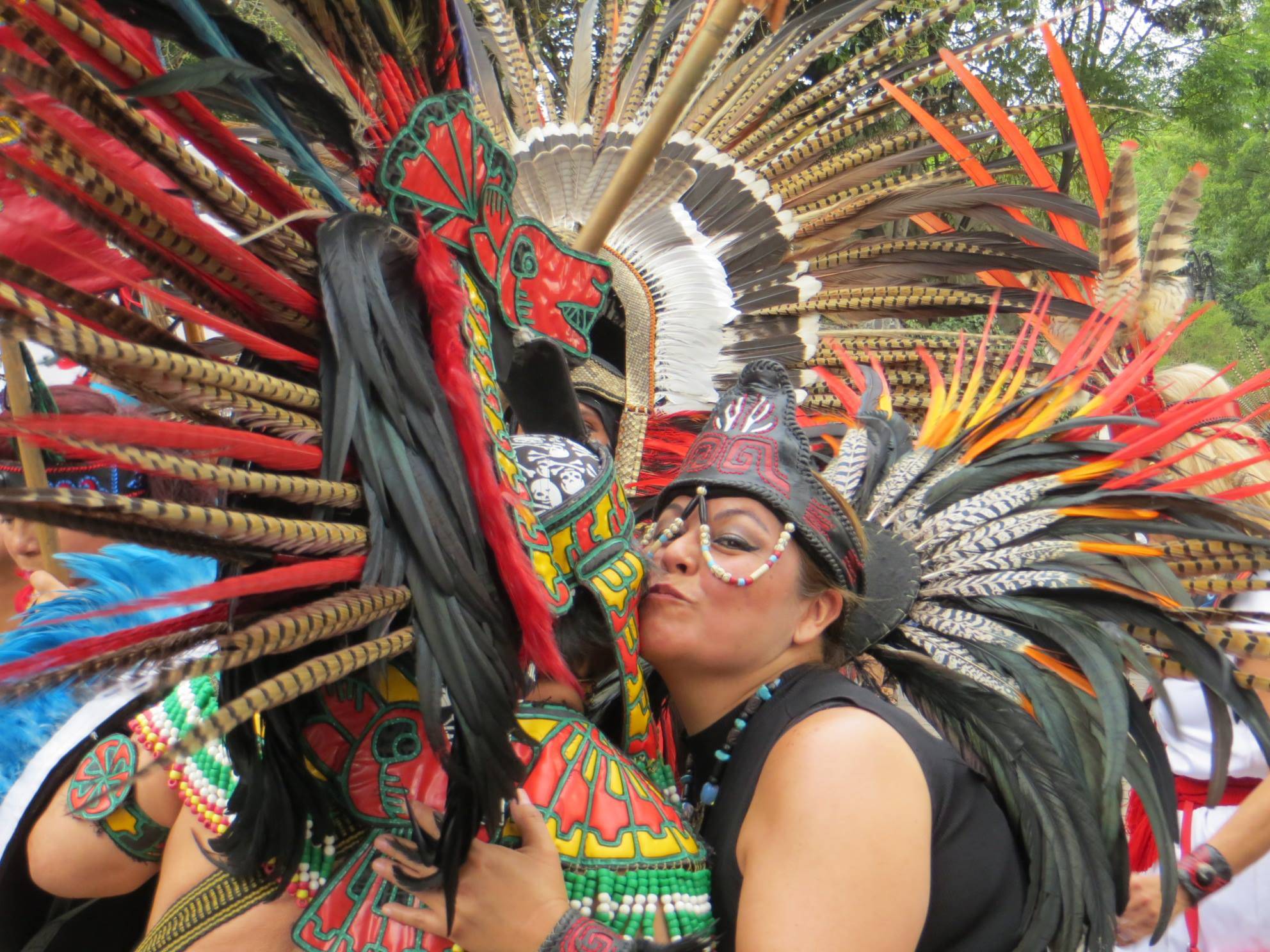 Samantha Pak/staff photo                                Two indigenous performers embrace during a break in their dancing in Plaza Coyoacán in Mexico City.