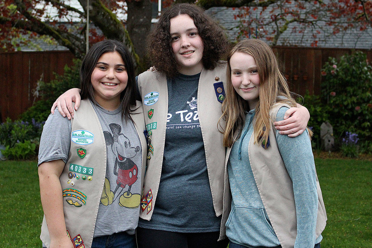 Madison Miller / staff photo                                Tillicum Middle School eighth-grade Girl Scouts are working to save endangered animals through an art contest. From left: Lola Rosenwald, Gwen Cable and Emma Rose Mulholland Salazar.