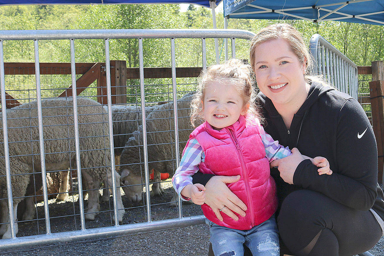 Stephanie Quiroz/staff photo                                 Claire Cannon and daughter Riley, 2, pose for a photo while enjoying the sheep at the annual sheep shearing event at Kelsey Creek Farm on April 27.