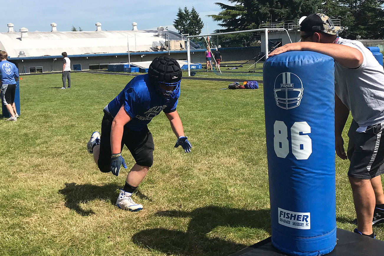 Bellevue Christian Vikings senior offensive lineman Sam Tefft runs full speed ahead before destroying a tackling dummy during a spring football practice session on June 4. Shaun Scott/staff photo