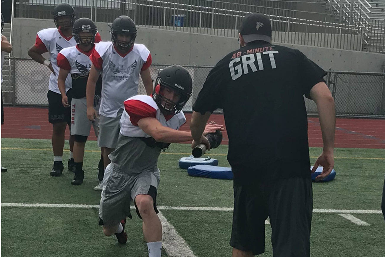 Sammamish Totems running back Benja Cook (pictured) goes through a set of drills during a spring practice session on June 5 at Sammamish High School in Bellevue. Shaun Scott/staff photo