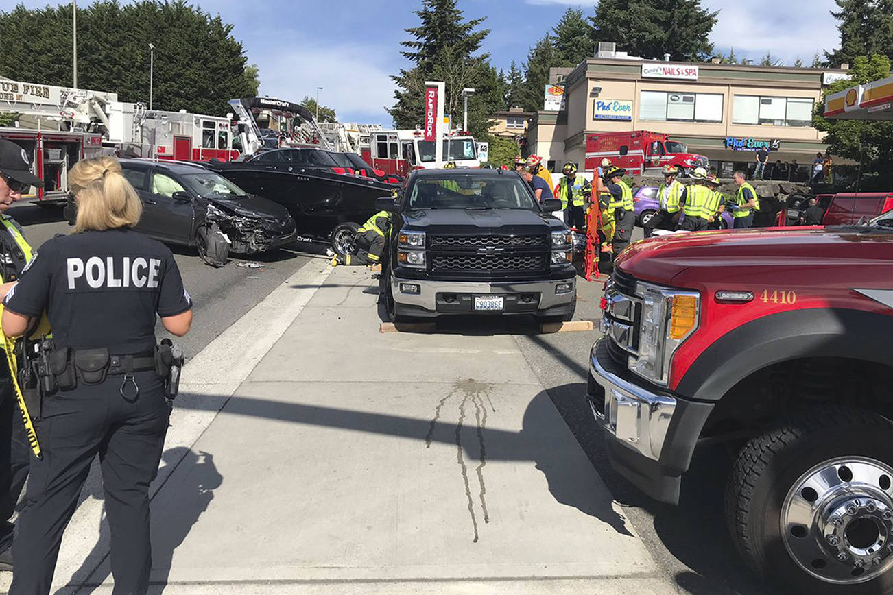 Car crash impact pushes truck into pedestrian