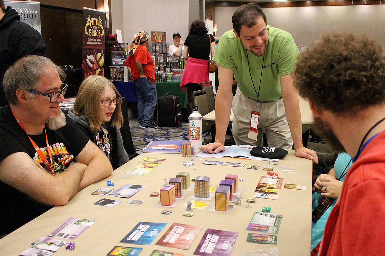 Madison Miller / staff photo                                Walter Lutsch, center, hosts Batman: Gotham City Under Siege at the 40th annual Dragonflight GameCon at the Bellevue Hilton hotel.