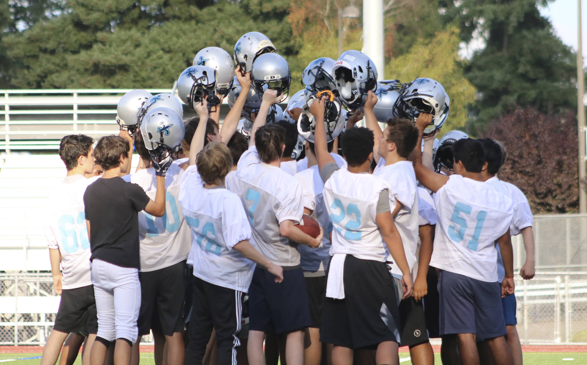 Interlake players raise their helmets at the end of practice. Benjamin Olson/ staff photo