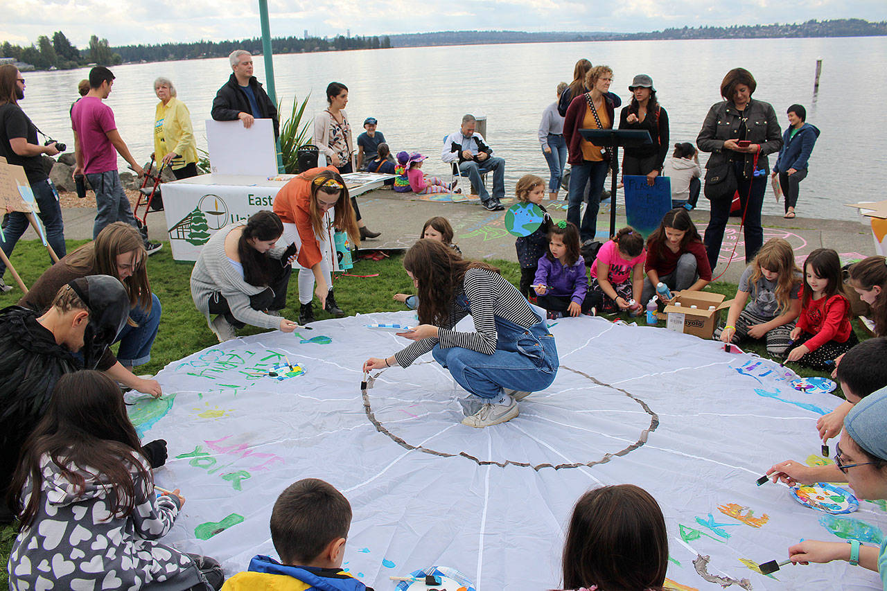 Amelia Hawkins leads the kids in painting a donated parachute at Friday’s climate strike. Madison Miller/staff photo