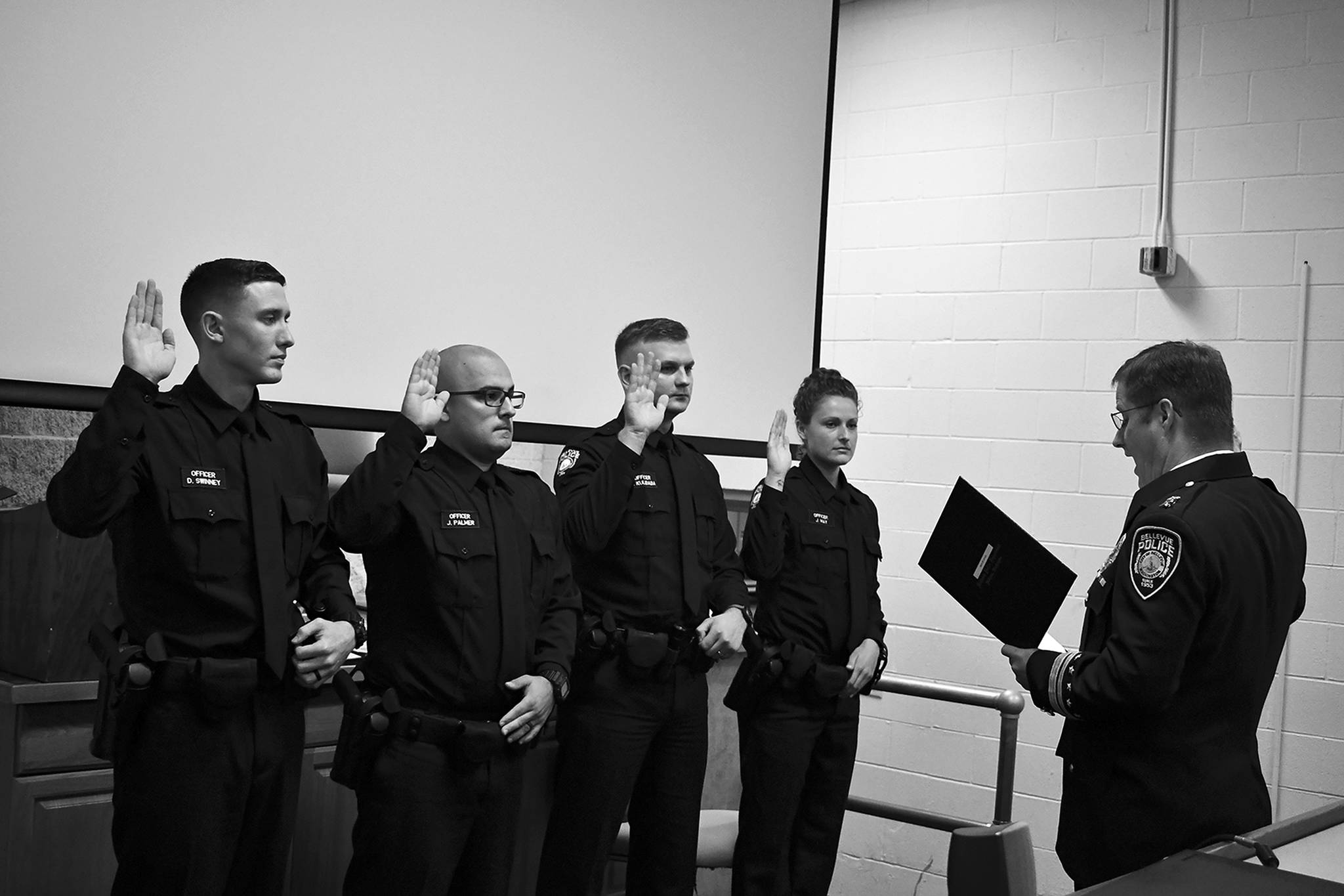 New Bellevue recruits Dimitry Kulibaba, Jennifer May, Jonathan Palmer and David Swinney are sworn in on July 11. The police department has hired 21 total officers this year. Photo courtesy of Bellevue Police Department