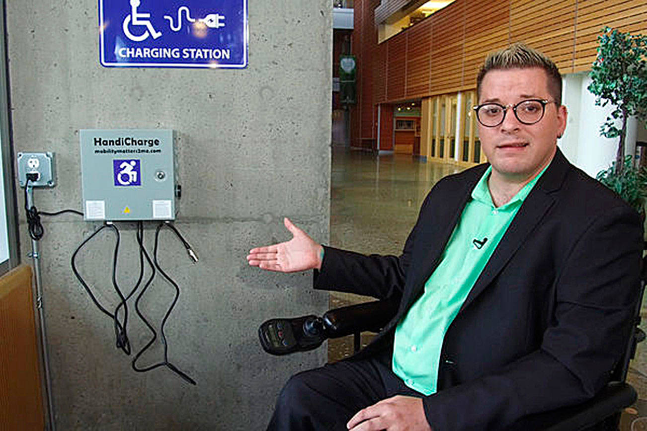 Blayne Amson, the ADA/Title VI Administrator for Bellevue, showcases one of the six new wheelchair charging stations in the city. Courtesy photo