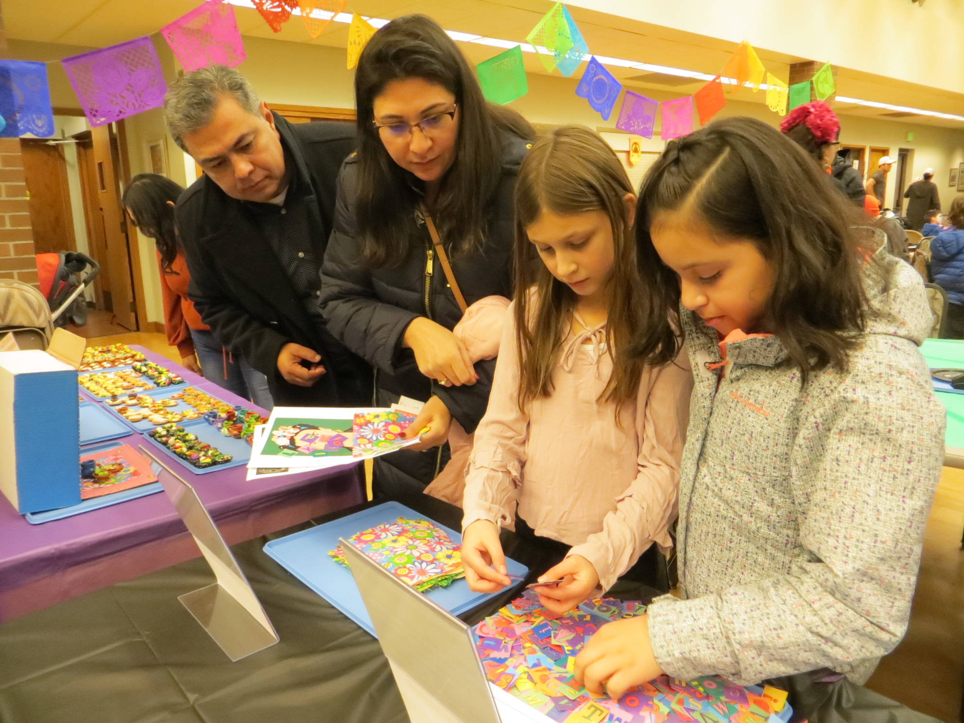 From left, Luis Nunez, Catalina Nunez, Angie Nunez and Leslie Gonzalez pick out items at the Dia De Los Muertos celebration in downtown Issaquah. The items are for a miniature altar they will create as a family. Samantha Pak/staff photo