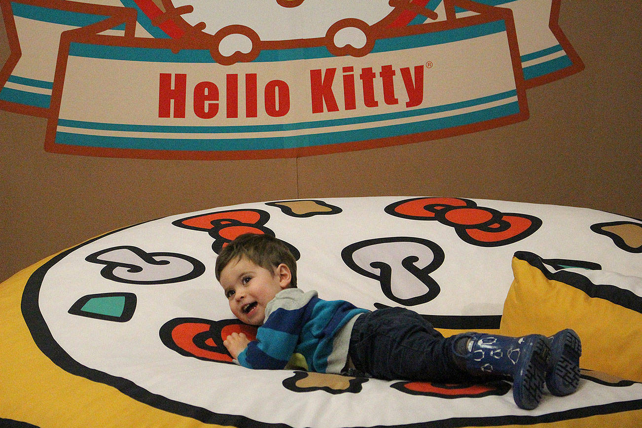 Two-year-old Chase Carlberg flops onto the plush Hello Kitty pizza at the Dec. 7 opening of the Hello Kitty Friends Around the World Tour Pop-Up in Bellevue. Madison Miller/staff photo