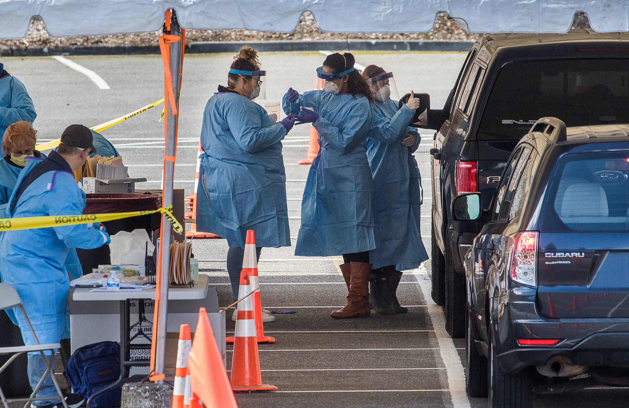 Drive-thru COVID-19 virus testing last week in the parking lot near Everett Memorial Stadium in Everett. A study by the University of Washington and UnitedHealth Group, conducted at Everett Clinic locations, found that a less-intrusive form of the coronavirus test would require fewer precautions by health care workers. (Andy Bronson / The Herald)