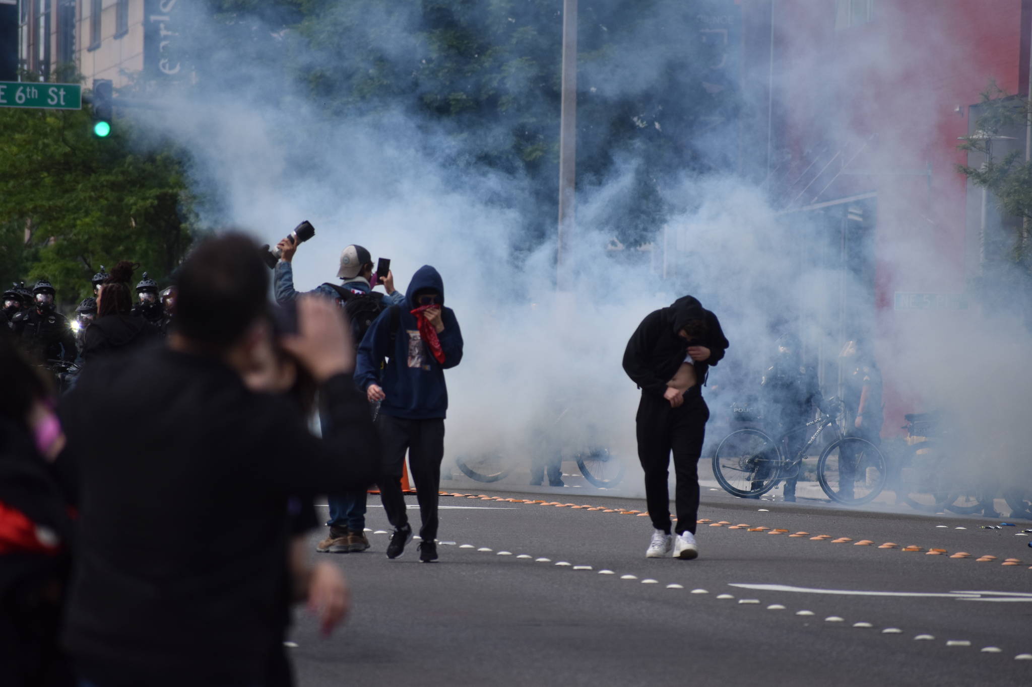 Protesters fall back from clouds of smoke and tear gas at a protest May 31 in downtown Bellevue. Photo by Haley Ausbun/Sound Publishing