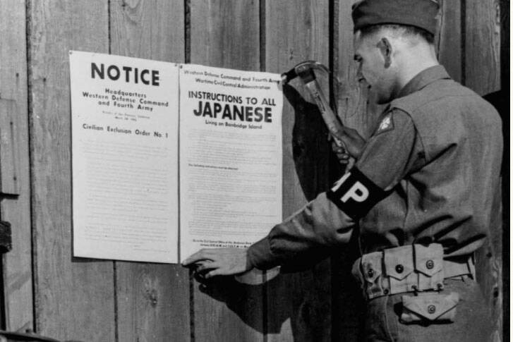 Military police posting Civilian Exclusion Order No. 1, requiring evacuation of Japanese living on Bainbridge Island, Washington. (Courtesy of The Library of Congress)