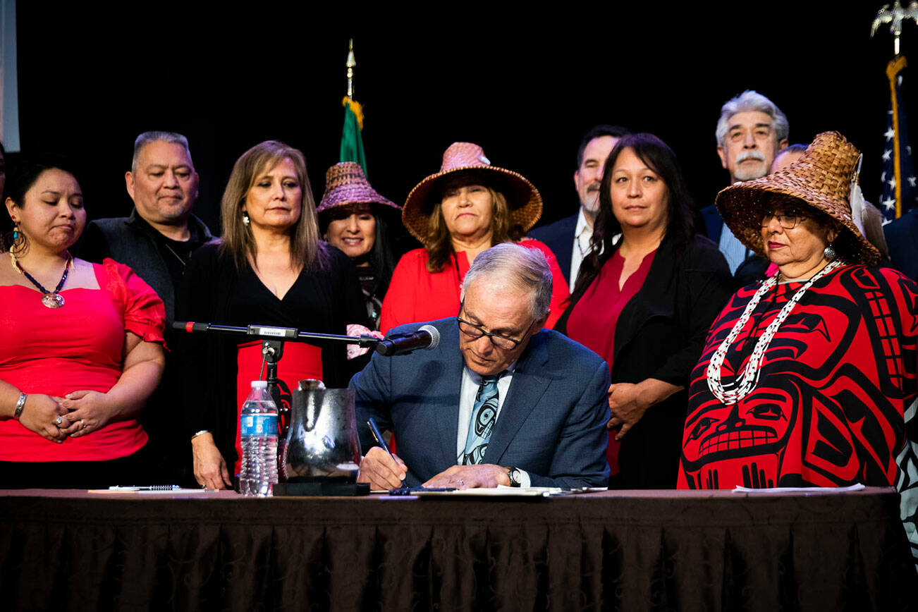 Tulalip council members and tribal members watch as Governor Jay Inslee signs bill HB 1571 into law at the Tulalip Resort on Thursday, March 31, 2022 in Tulalip, Washington. (Olivia Vanni / The Herald)