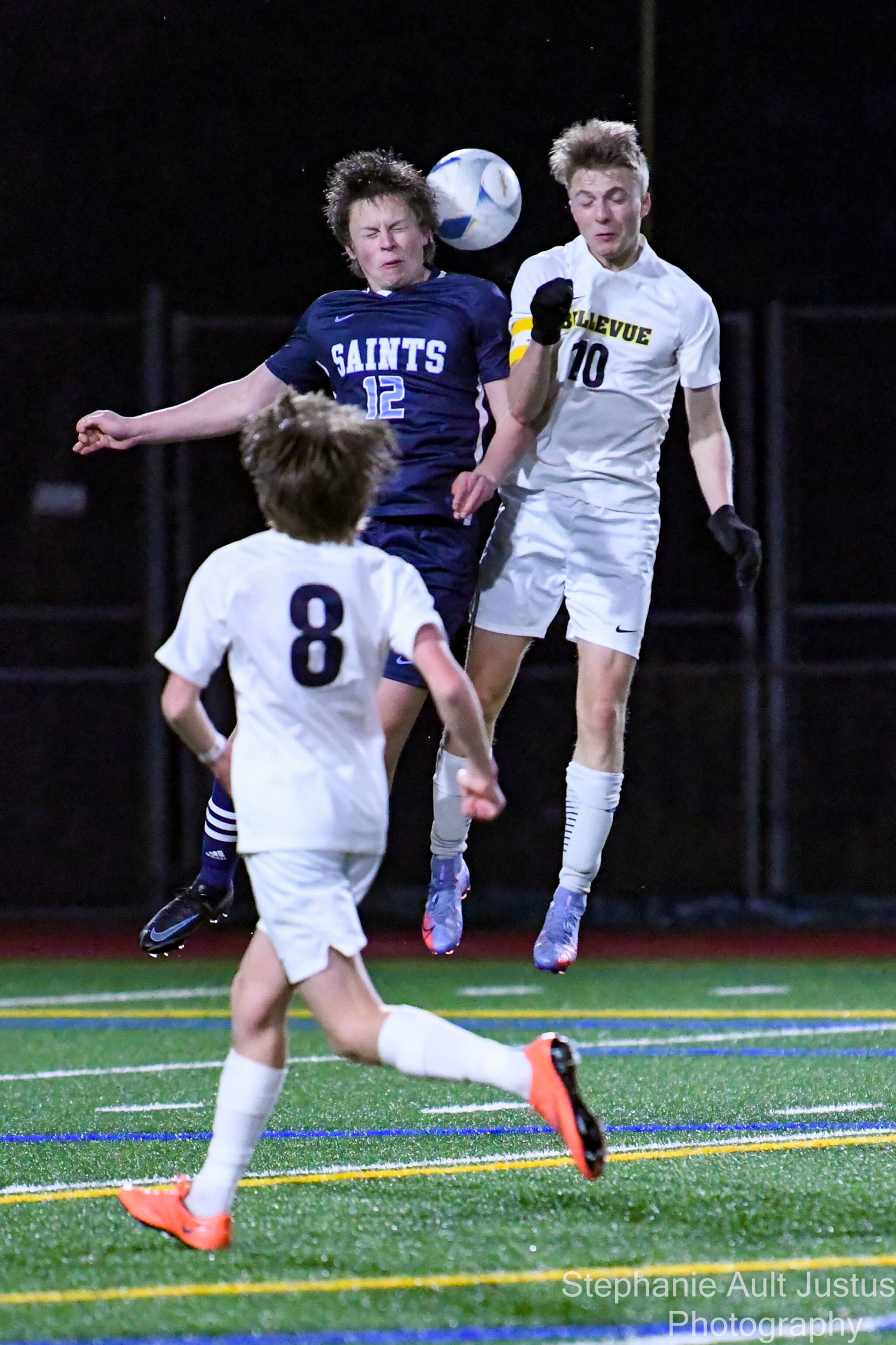 Interlake junior Isaac Dyor (#12) and Bellevue senior Edmund Justus (#10) jump for the ball as sophomore Cole Capriotti (#8) looks on. Courtesy of Stephanie Ault Justus.