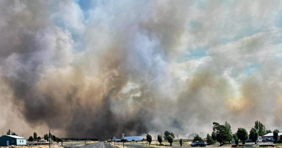 This photo provided by the Washington State Department of Transportation shows smoke from a wildfire burning south of Lind, Wash., on Thursday, Aug. 4, 2022. Sheriff’s officials are telling residents in the Eastern Washington town to evacuate because of a growing wildfire south of town that was burning homes. (Courtesy photo)