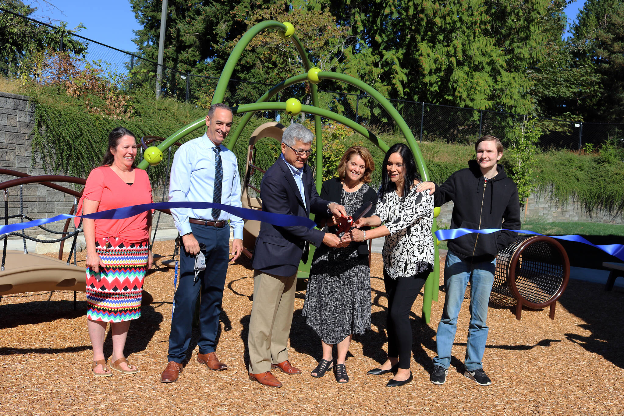 Gary Locke and Sheri Flies (center) cut a ribbon to celebrate the ELC playground renovation on September 6. Courtesy of Bellevue College.