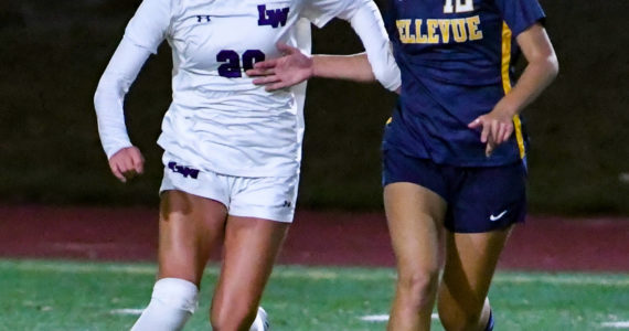 Bellevue senior Leah Uezato (#12) controls the ball while Lake Washington senior and captain, Ella Studer (#20) attempts to steal it. Courtesy of Stephanie Ault Justus.