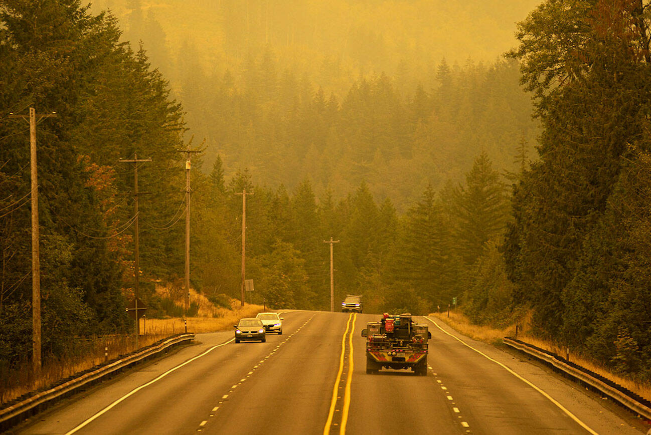 An emergency fire vehicle heads past a barricade and towards Index as numerous agencies attempt to contain the Bolt Creek Fire on Saturday, Sep. 10, 2022, on U.S. Highway 2 near Index, Washington. (Ryan Berry / The Herald)