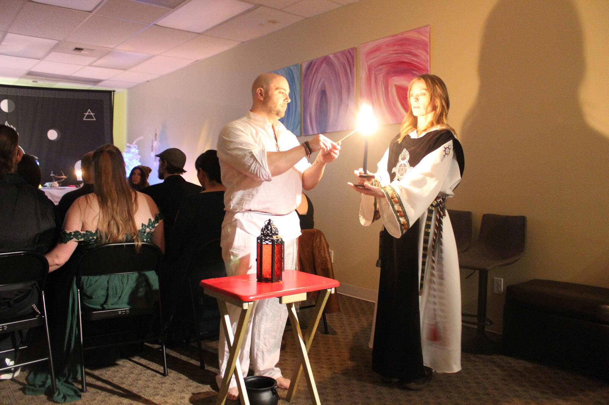 High Priest Kalu and High Preistess Syleena “Call The Corners,” a small ritual where a candle is lit at each direction of the Earth as the elements of each direction is called upon. Here they call on the guardian of the watchtower of the South, represented by red which symbolizes fire. Photo by Bailey Jo Josie/Sound Publishing.